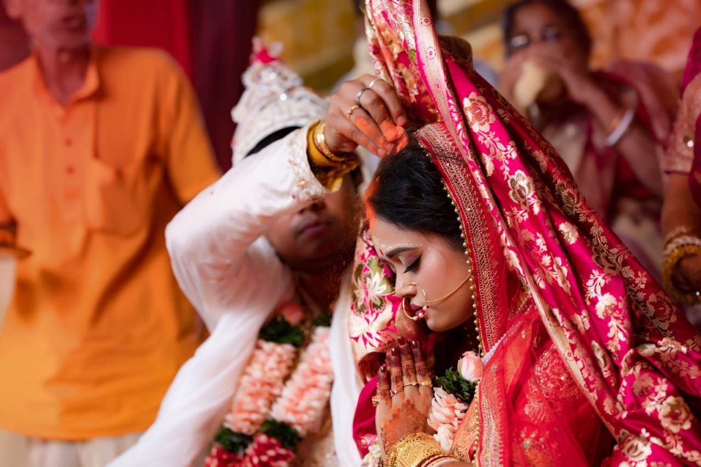 Bride and groom perform traditional wedding rituals in a vibrant cultural ceremony.